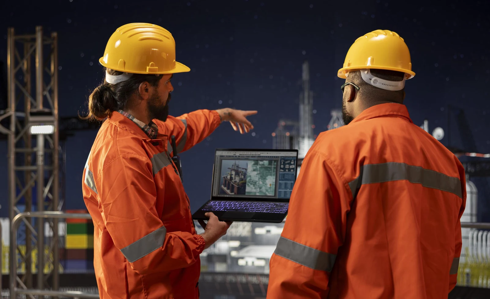 Tecnici con dispositivi digitali e dispositivi di protezione in cantiere